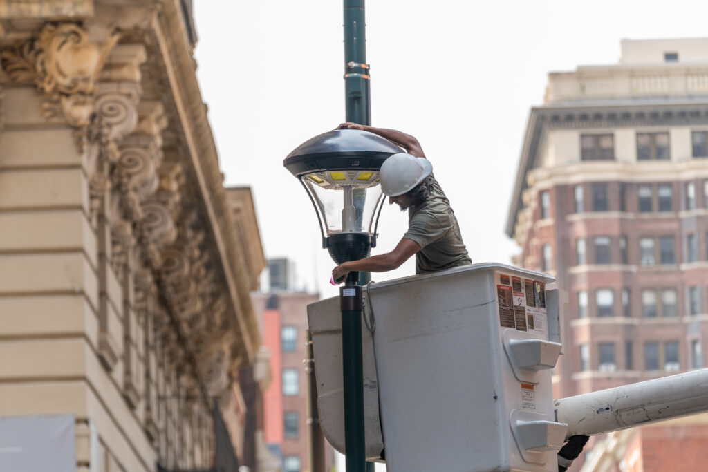 A person installing our Phoenix Smart Fixture on the street.